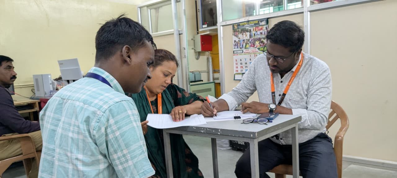  HTBF Staff Interacting with a student during the scholarship drive, filling out application forms at a desk.