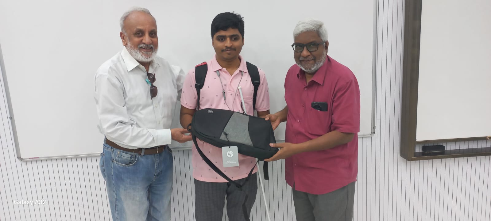 Naresh Kumar Receiving laptop from HTBF Trustee Mr. Sunder Kumar and IIT Madras Professor Mr.Prakash Sai