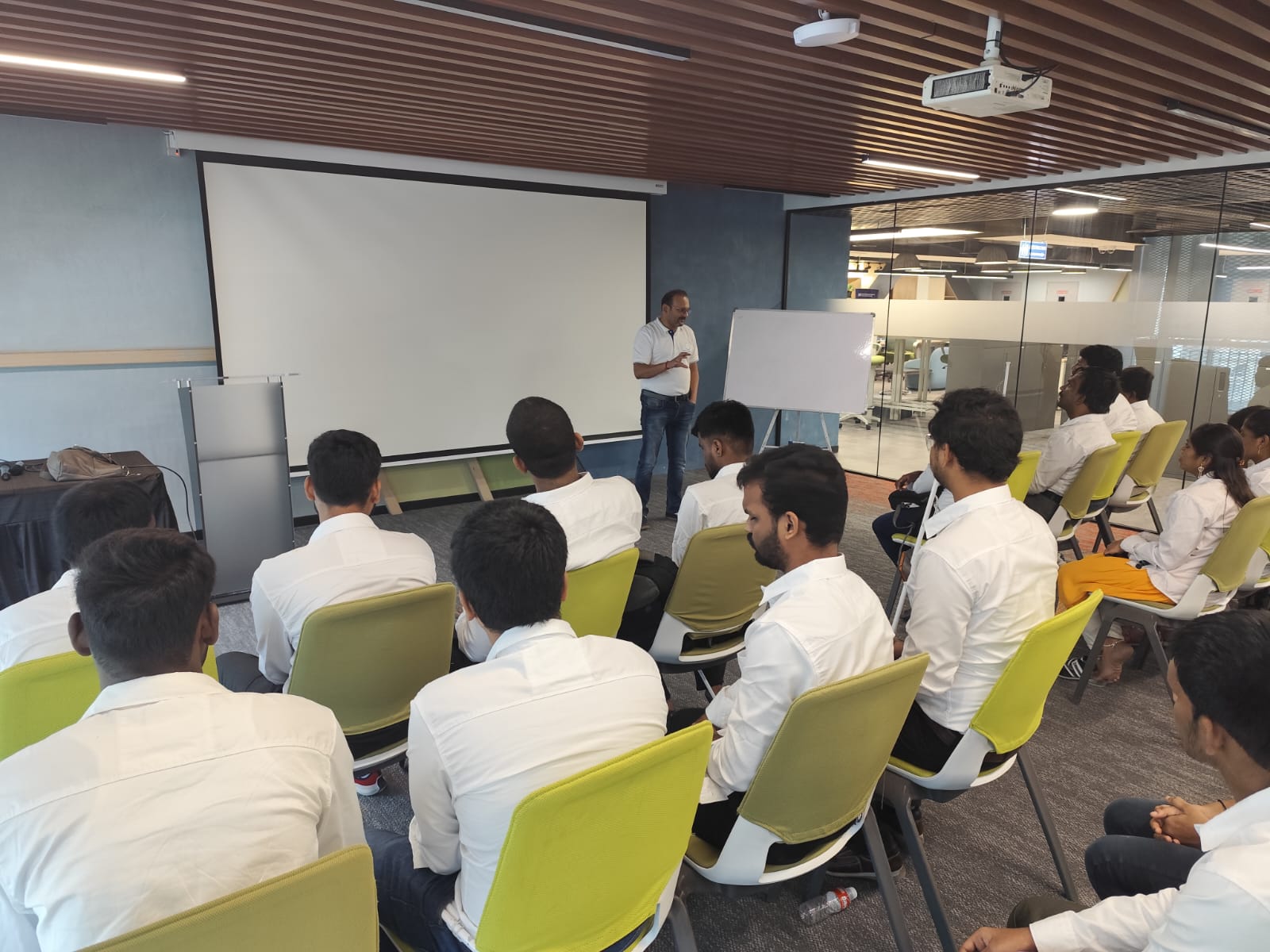 A Classroom setting where visually impaired trainees sit on chairs attentively listening to the speaker.