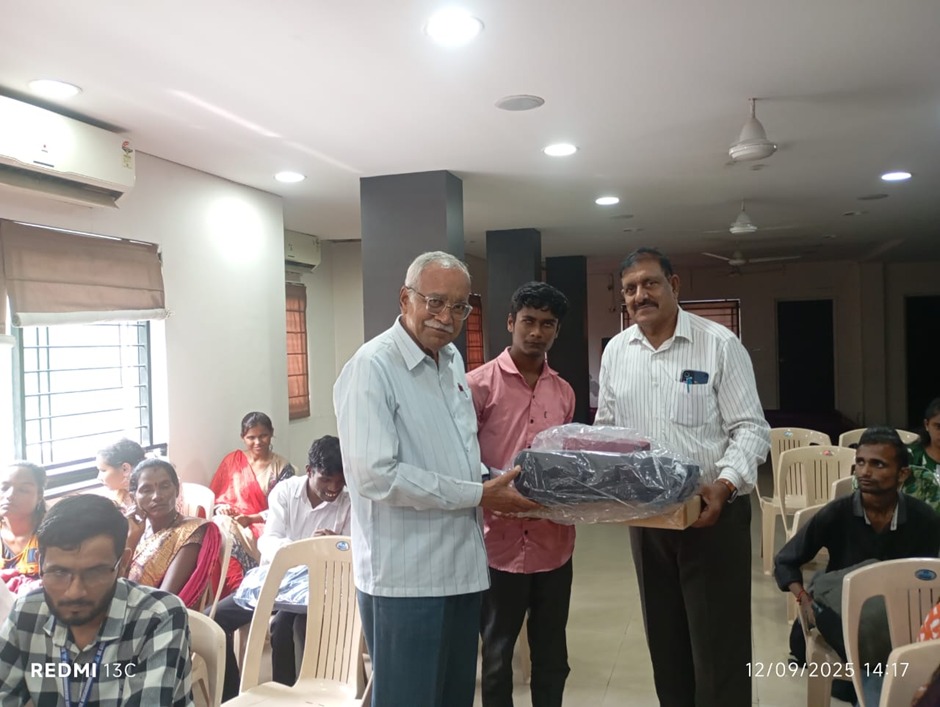 A Beneficiary receiving laptop and svg from the HTBF Dignitaries.