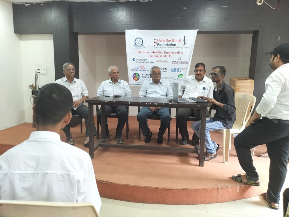 A photo of HTBF Dignitaries with a visually impaired student using a laptop