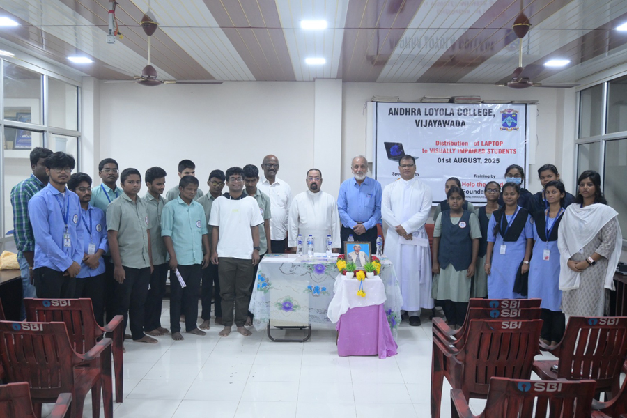 Group Photo of Dignitaries from HTBF and Andhra Loyola College with visually impaired students during laptop distribution.