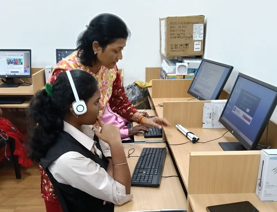  A trainer helping a student with the laptop.