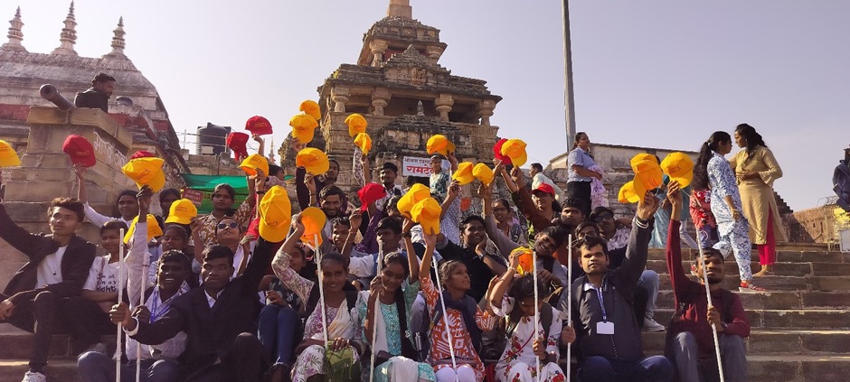  Visually impaired students from Nagpur wearing yellow caps and holding white canes pose as a group during a heritage walk.