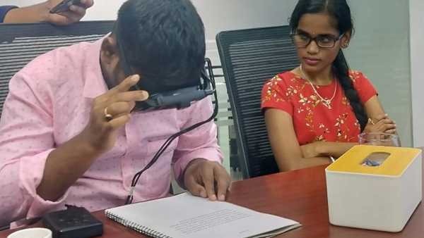 A Visually impaired student reading a document with the help of Smart Vision Glasses (SVG).